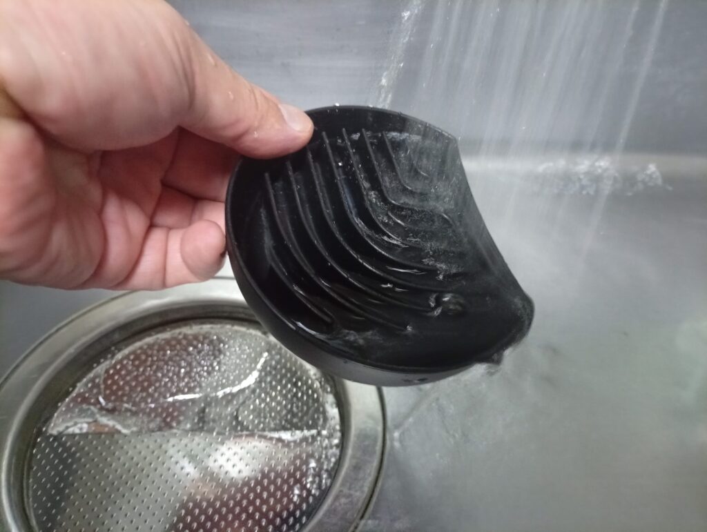 ドルチェグストのカップを置くトレイを取り外して流水ですすぐ様子