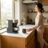 一人暮らしのキッチンで朝のコーヒータイムを楽しむ女性とコンパクトなコーヒーメーカー