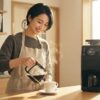 Toffy K-CM9で淹れたてのブラックコーヒーを白いカップに注ぐ日本人女性の朝のキッチンシーン