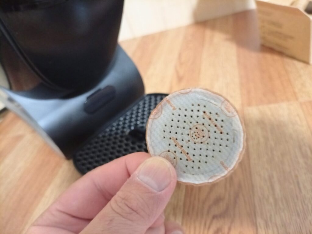 抽出後に穴が開いたドルチェグストNEOの使用済み紙製ポッド