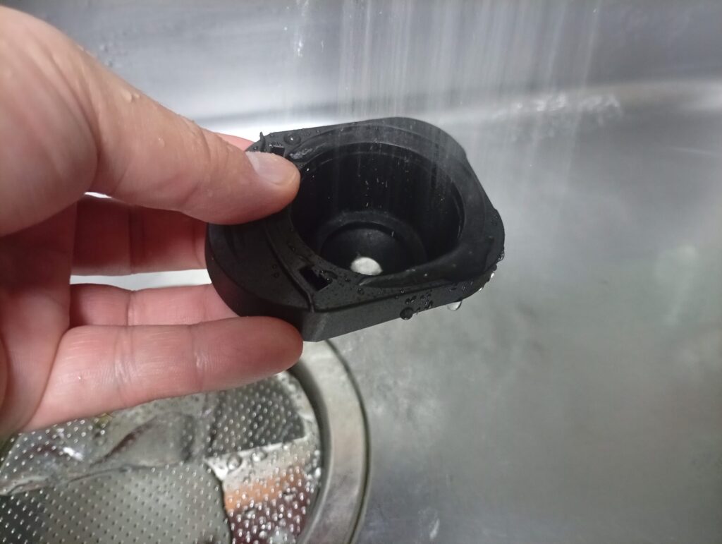 ドルチェグストのカプセルホルダーを取り外して内側を流水ですすぐ様子